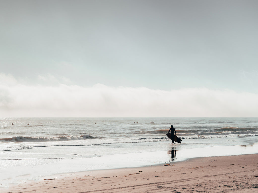 Surfer idący w stronę oceanu