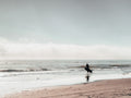 Surfer idący w stronę oceanu