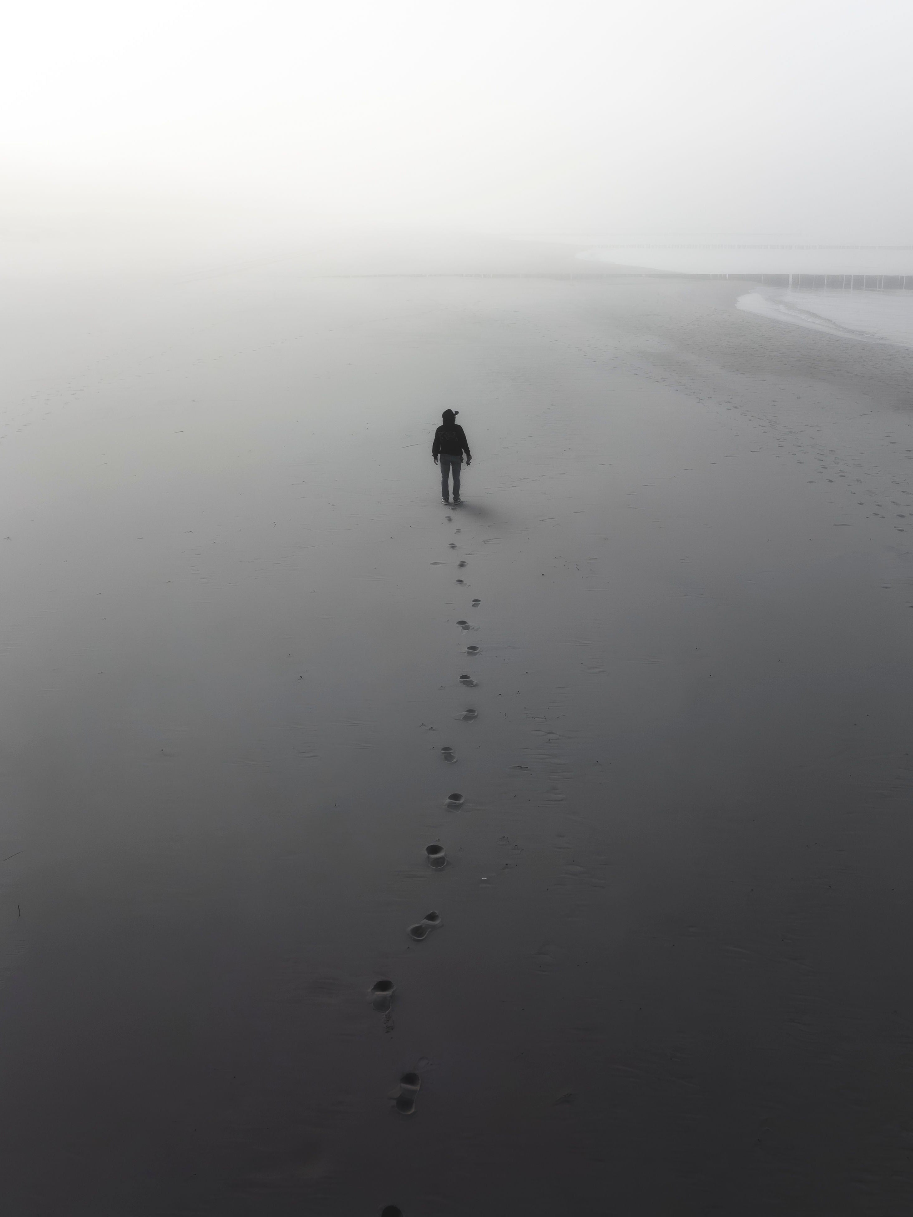 Sylwetka człowieka na zamglonej plaży
